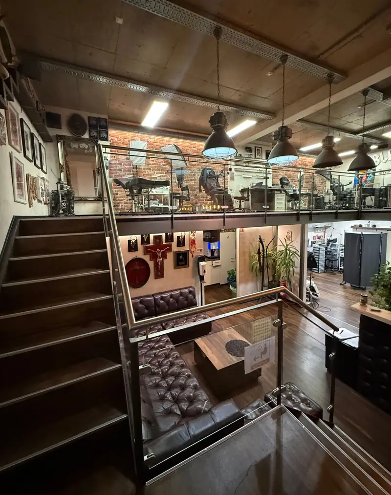 Das Studio von Black & White Tattoo in Karlsruhe: Empore mit Backsteinwand, Industrielampen und Lounge